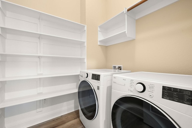 laundry room featuring laundry area, wood finished floors, and separate washer and dryer