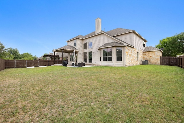 rear view of property with a patio, a fenced backyard, a chimney, a gazebo, and a lawn