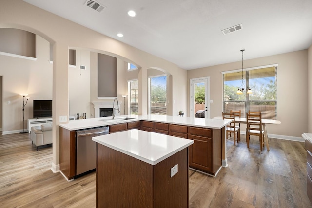 kitchen featuring a kitchen island, visible vents, a sink, and dishwasher