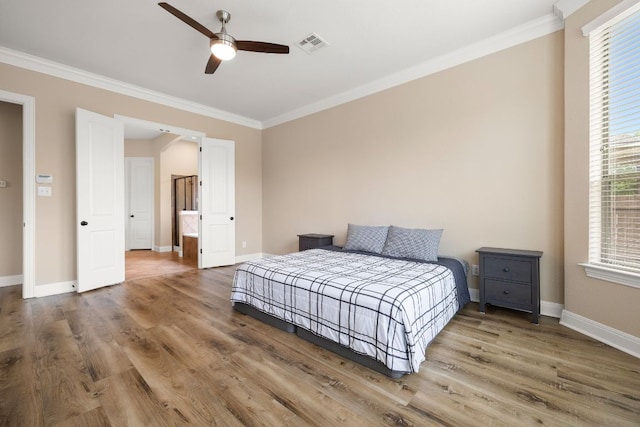 bedroom featuring baseboards, visible vents, ornamental molding, and wood finished floors