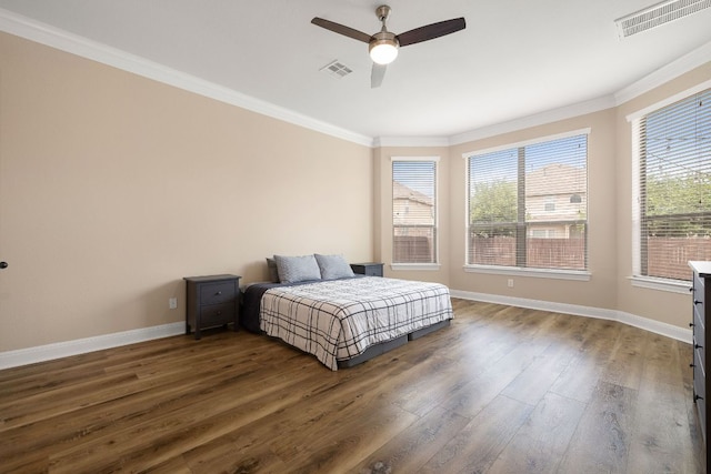 bedroom featuring baseboards, ornamental molding, dark wood-style floors, and visible vents