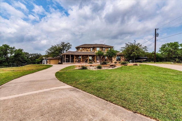 view of front facade featuring curved driveway, an attached garage, and a front lawn