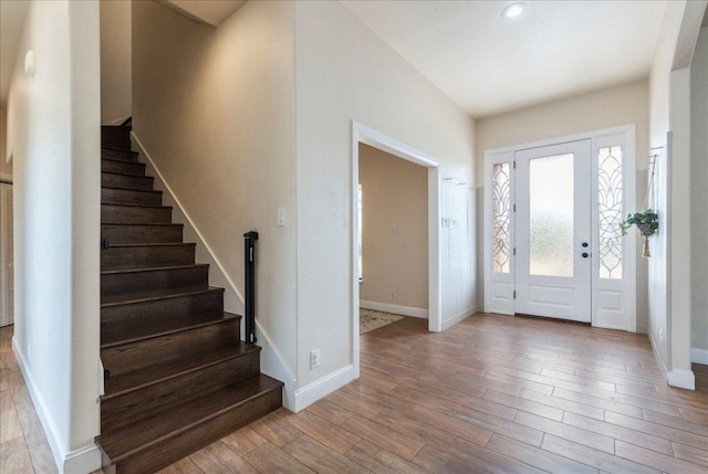 entryway featuring stairway, baseboards, and wood finished floors