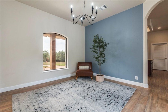 3904 Bee Creek Rd, Spicewood, TX 78669 - sitting room with arched walkways, wood finished floors, a chandelier, and baseboards