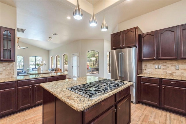 kitchen with stainless steel appliances, visible vents, lofted ceiling, and tasteful backsplash