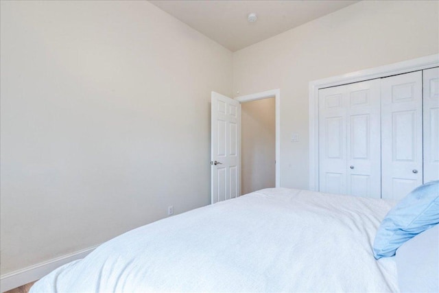 bedroom featuring baseboards and a closet