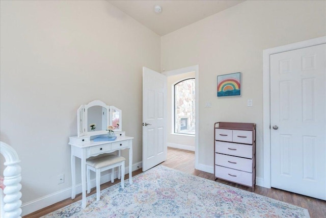 bedroom featuring baseboards, vaulted ceiling, and wood finished floors