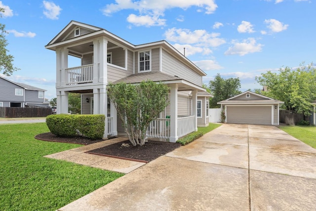 view of front facade with a porch, a balcony, an outbuilding, and a front yard