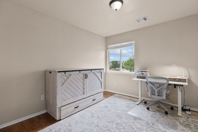 office featuring baseboards, visible vents, and wood finished floors