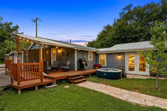 back of property featuring a lawn, metal roof, cooling unit, and french doors