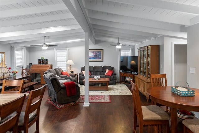 living area with dark wood-style flooring, a ceiling fan, and vaulted ceiling with beams