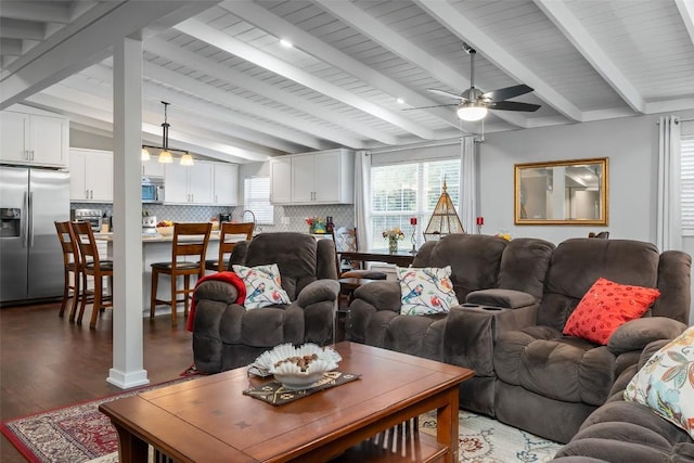 living room featuring lofted ceiling with beams, a ceiling fan, and wood finished floors