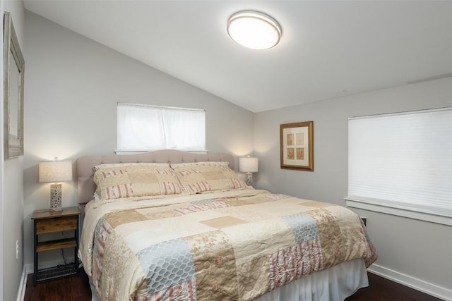 bedroom with baseboards, dark wood finished floors, and lofted ceiling