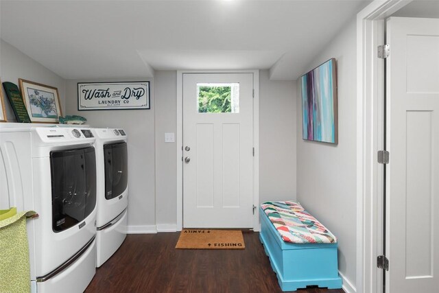 washroom with dark wood-style flooring, baseboards, washing machine and dryer, and laundry area