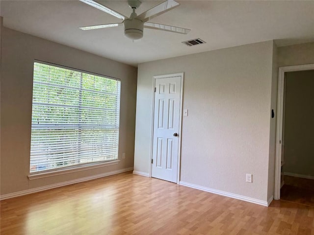 unfurnished room featuring visible vents, a ceiling fan, baseboards, and light wood-type flooring
