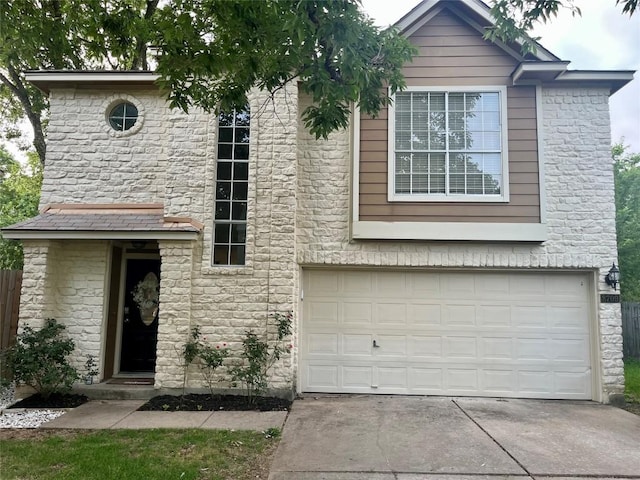 view of front of property with driveway, stone siding, and a garage