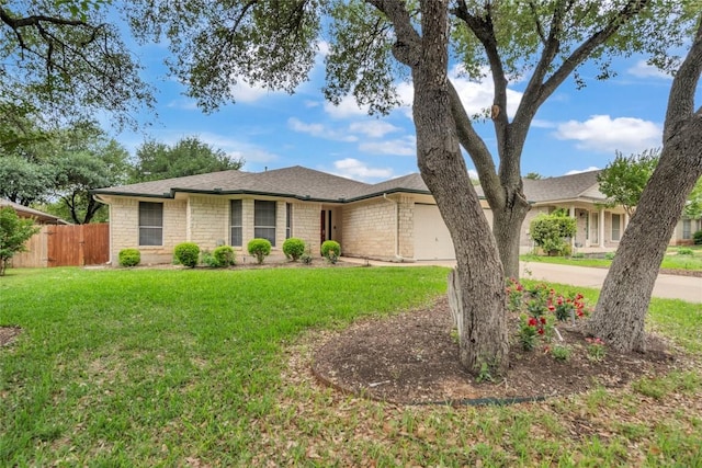 ranch-style home featuring a garage, a front lawn, fence, roof with shingles, and driveway