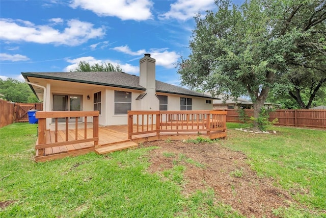 rear view of property with roof with shingles, a deck, a fenced backyard, a chimney, and a yard