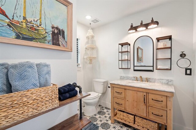 bathroom with visible vents, vanity, toilet, baseboards, and recessed lighting