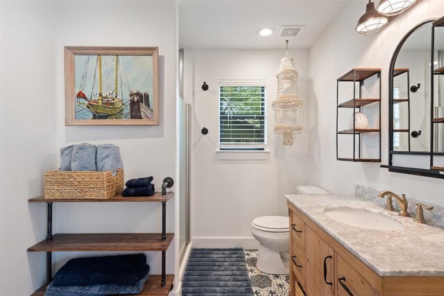 full bath featuring toilet, baseboards, walk in shower, and vanity