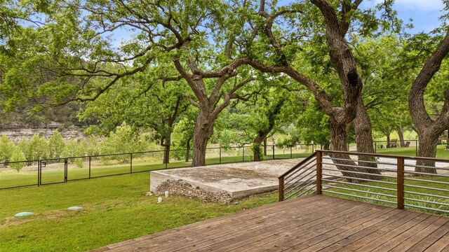 wooden terrace featuring a yard and fence