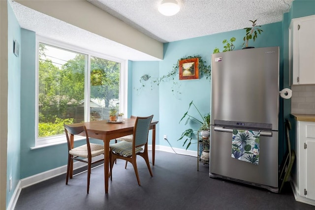 dining room with baseboards and a textured ceiling