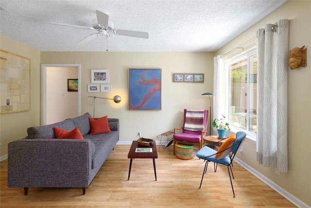 interior space with baseboards, a textured ceiling, ceiling fan, and wood finished floors