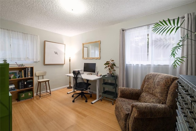 office featuring baseboards, a textured ceiling, and wood finished floors