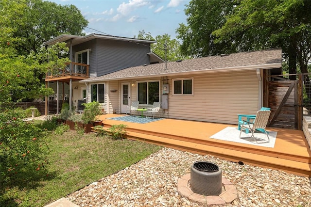 back of property with a deck and a balcony