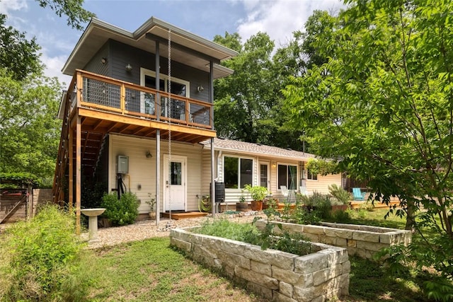 back of house featuring stairs and a wooden deck
