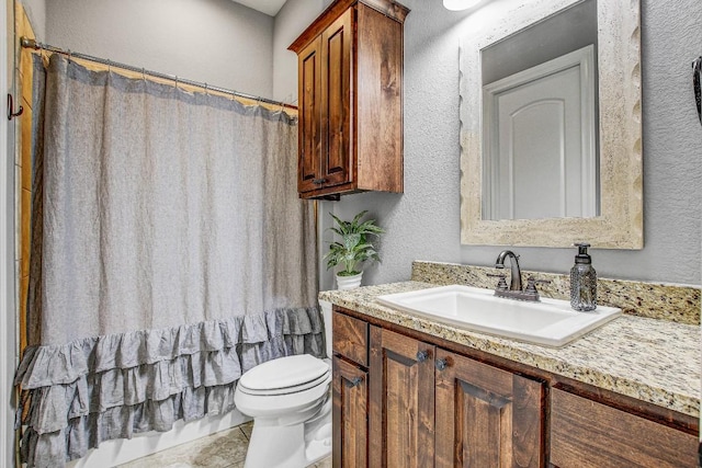 full bathroom featuring vanity, a textured wall, a shower with curtain, and toilet