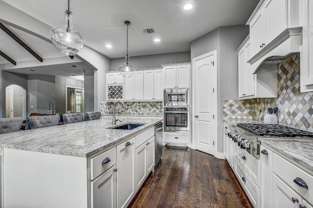 kitchen featuring white cabinets, a sink, stainless steel appliances, recessed lighting, and tasteful backsplash