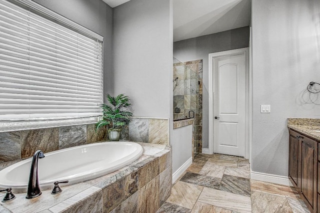 full bath with a healthy amount of sunlight, baseboards, a stall shower, and a bath