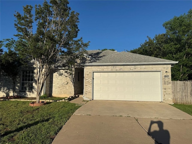 ranch-style home with concrete driveway, brick siding, an attached garage, and a front yard