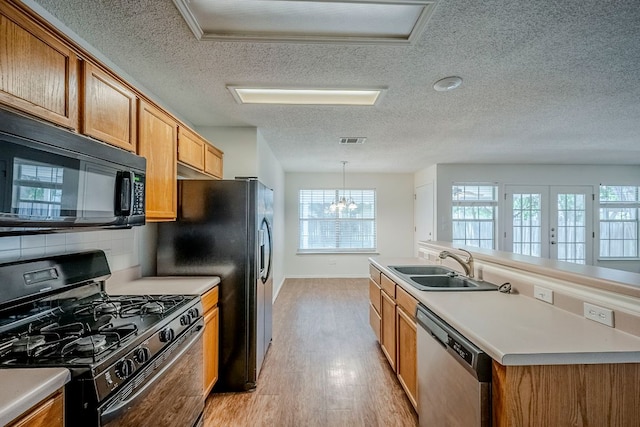 1911 Timberwood Dr, Cedar Park, TX 78613 - kitchen featuring black appliances, a sink, a textured ceiling, light wood-style flooring, and plenty of natural light