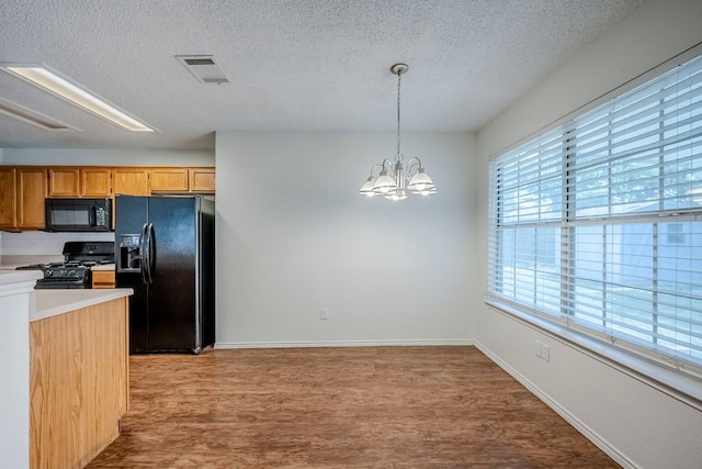1911 Timberwood Dr, Cedar Park, TX 78613 - kitchen featuring black appliances, light wood-type flooring, a textured ceiling, a chandelier, and light countertops