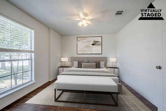 1911 Timberwood Dr, Cedar Park, TX 78613 - bedroom with multiple windows, a textured ceiling, wood finished floors, a ceiling fan, and baseboards