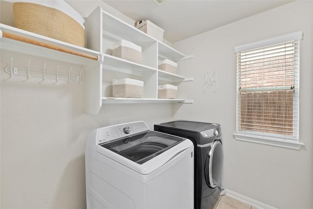 laundry area with washer and dryer, light tile patterned floors, laundry area, and baseboards