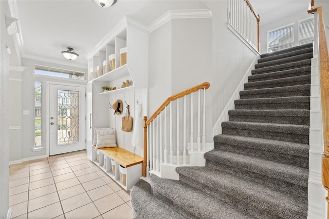 mudroom with crown molding, light tile patterned flooring, baseboards, and plenty of natural light