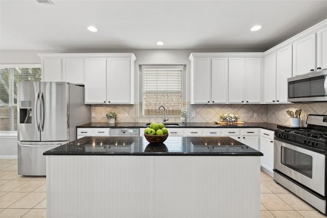 kitchen with white cabinets, stainless steel appliances, a sink, and light tile patterned flooring