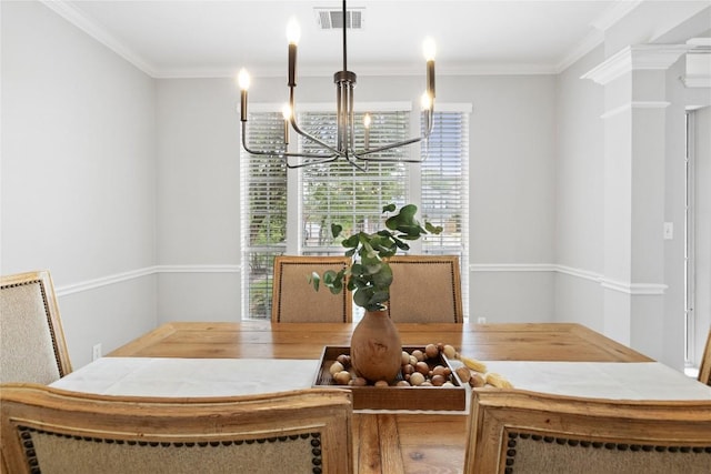dining area featuring visible vents, ornamental molding, and a notable chandelier