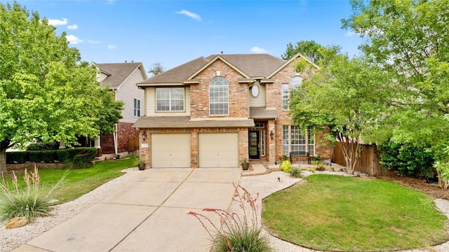 view of front facade featuring a garage, fence, a front yard, brick siding, and driveway