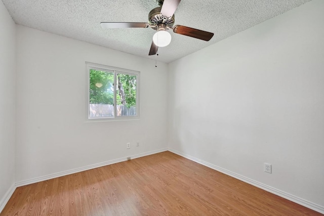 empty room featuring baseboards, a textured ceiling, ceiling fan, and wood finished floors