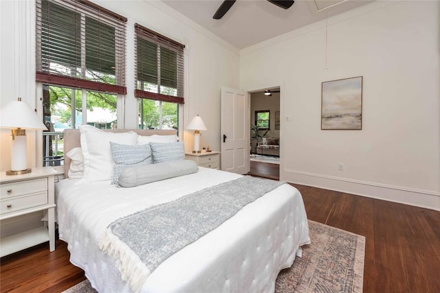 bedroom with ceiling fan, attic access, wood finished floors, baseboards, and ornamental molding