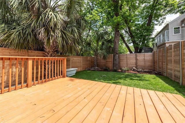 deck with a lawn and a fenced backyard