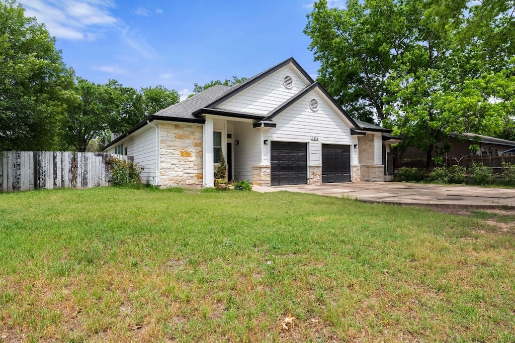 1214 Vargas Rd Unit A, Austin, TX 78741 - view of front facade with stone siding, an attached garage, and concrete driveway
