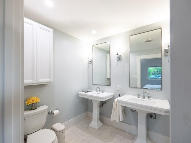 bathroom featuring visible vents, baseboards, tile patterned floors, and toilet