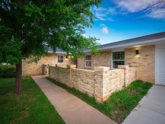 view of home's exterior featuring fence and brick siding