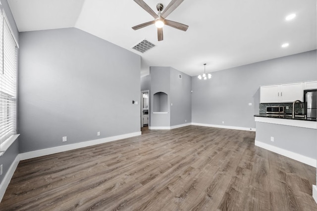 1214 Vargas Rd Unit B, Austin, TX 78741 - unfurnished living room with ceiling fan, vaulted ceiling, wood finished floors, a chandelier, and recessed lighting