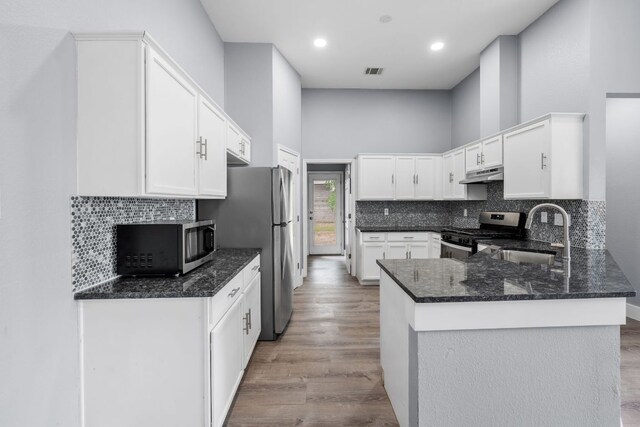 1214 Vargas Rd Unit B, Austin, TX 78741 - kitchen with appliances with stainless steel finishes, under cabinet range hood, a peninsula, wood finished floors, and recessed lighting